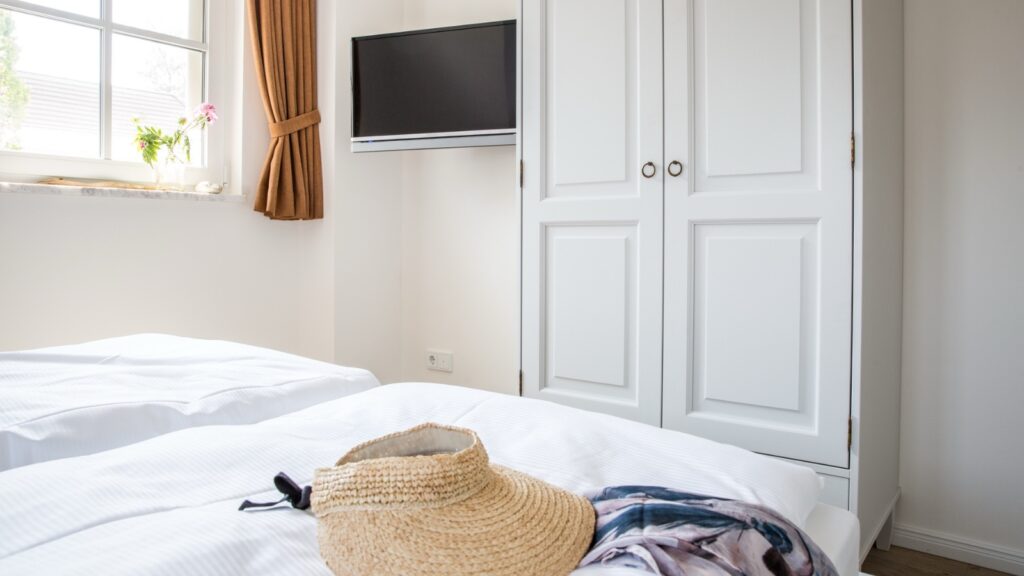 Schlafzimmer mit zwei Fenstern und TV in strandnaher Ferienwohnung in Zingst